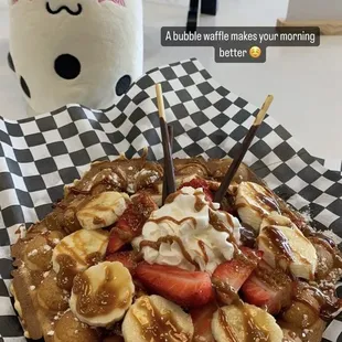 a waffle waffle with bananas, strawberries, and whipped cream