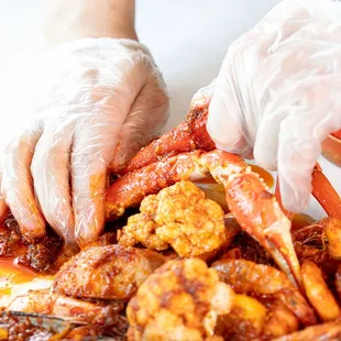 a person in white gloves preparing a dish