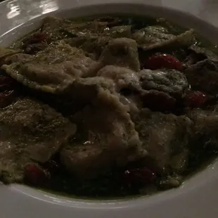 Mushroom Ravioli with pesto, cherry tomatoes and artichoke hearts.