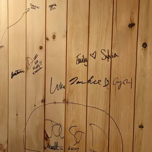 a wooden wall with writing on it