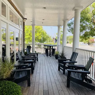 a porch with chairs and tables