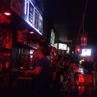 a man at a bar with neon lights
