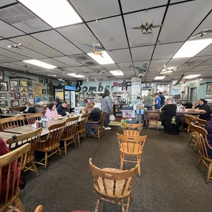 people sitting at tables in the middle of the room