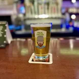 a glass of beer on a bar