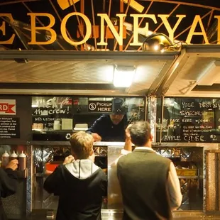a group of people standing in front of a food truck