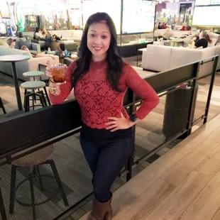 a woman holding a drink in a restaurant