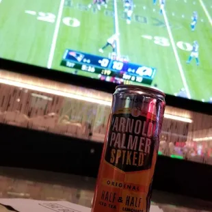 a can of beer on a table in front of a television