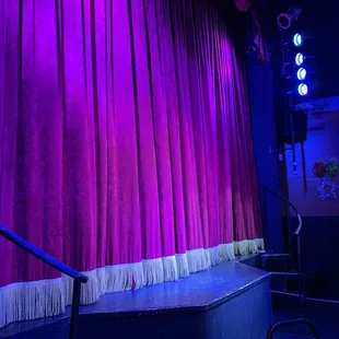 a stage with a purple curtain