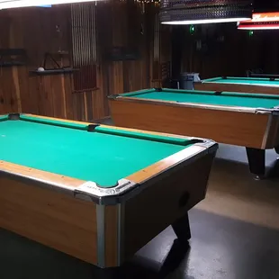 two pool tables in a dark room