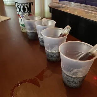 a row of plastic cups with spoons