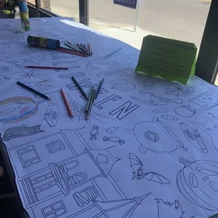 a table covered with coloring books and crayons