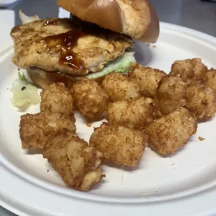 Spicy grilled chicken Sammy on brioche bun with tots