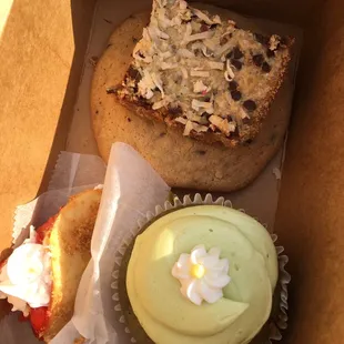 Green tea cupcake bottom right, top center chocolate chip walnut cookie under a magic bar. Also a fried cannoli with strawberries and cream.