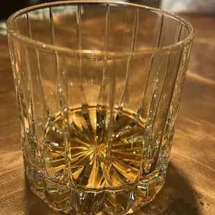 a glass of whiskey on a wooden table