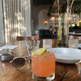 a cocktail with a lime garnish