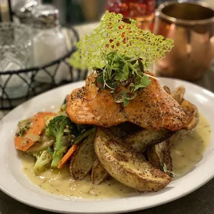 Salmon stuffed with fresh dungeness crab, roasted potatoes and vegetables with a delicious sauce