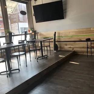 a view of a room with tables, chairs, and a flat screen tv