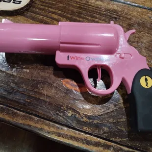 a pink toy gun on a wooden table