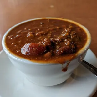 a bowl of chili soup on a saucer