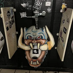 a bathroom stall with graffiti on the walls