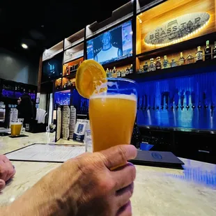 a person holding a glass of orange juice