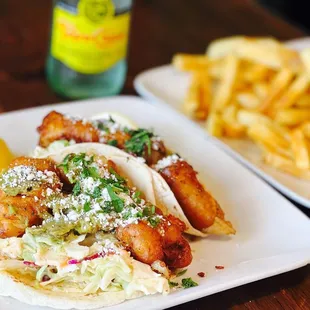 a plate of fish tacos and french fries