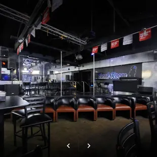 tables and chairs in front of a bar