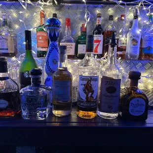 bottles of alcohol lined up on a bar
