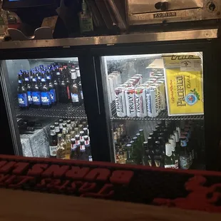 a bar with a cooler full of beer