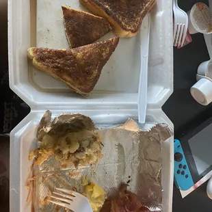 Breakfast plate with French toast, eggs, potatoes and bacon