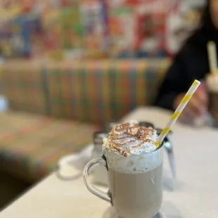 a cup of coffee with a straw in it