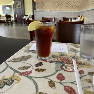 a glass of iced tea with a lemon wedge