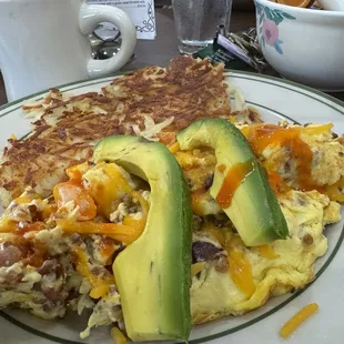 Bacon tomato and avocado omelet cooked as a scramble with cheddar cheese