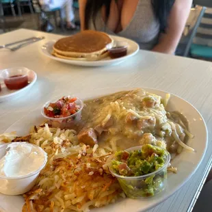 a woman sitting at a table with a plate of food