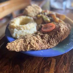 Catfish, grits, biscuit, and potatoes