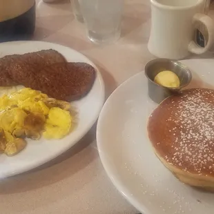 a plate of pancakes, eggs, hash browns, and hash browns