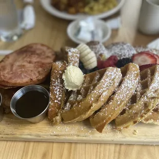 The breeze breakfast board Pancakes, Toast, Ham, bacon, and Fruit.