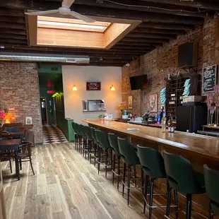 a long bar with green chairs