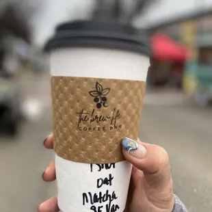 a hand holding a cup of coffee