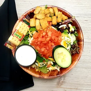 a bowl of salad and crackers