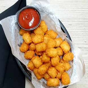 a basket of tater tots and ketchup