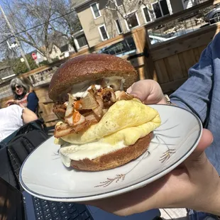 a person holding a plate with a sandwich on it