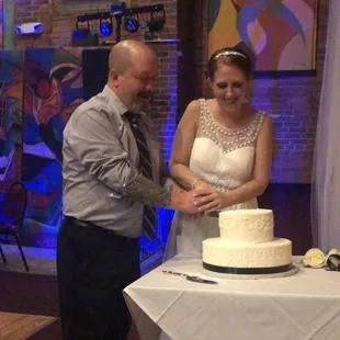 a bride and groom cutting their wedding cake