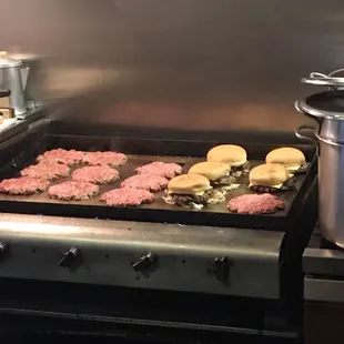 hamburgers being cooked on the stove