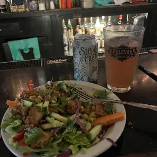 a plate of salad and a glass of beer