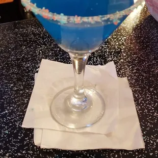 a blue drink in a martini glass
