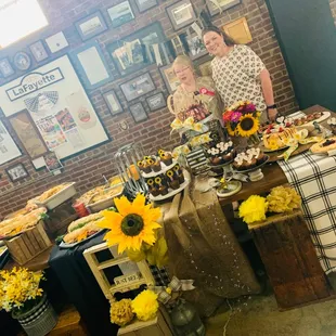 a woman standing in front of a table full of food