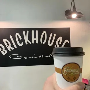 a hand holding a cup of coffee