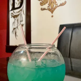a green drink in a bowl with two straws
