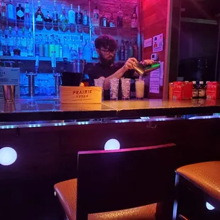 a bartender pouring a drink at the bar